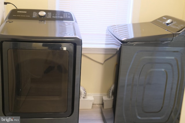 washroom featuring washer and clothes dryer and wood finished floors