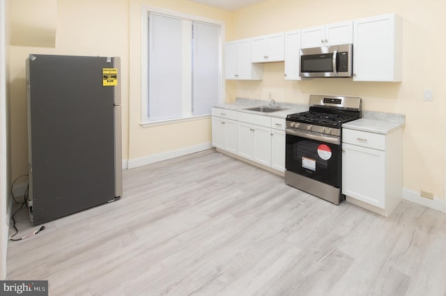 kitchen featuring a sink, light countertops, white cabinetry, and stainless steel appliances