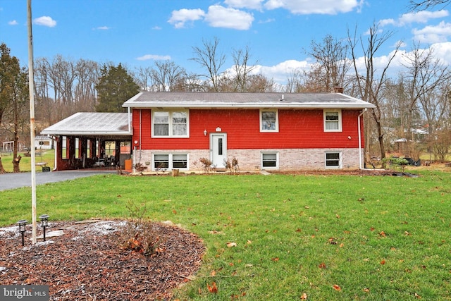 rear view of property with a carport and a lawn