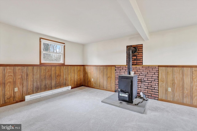 unfurnished living room featuring baseboard heating, a wood stove, light carpet, and beamed ceiling