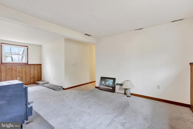 carpeted empty room with wooden walls