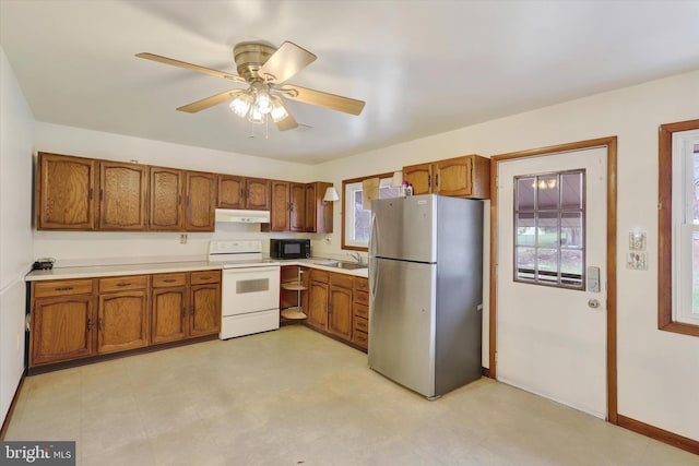 kitchen with stainless steel fridge, white range with electric cooktop, ceiling fan, and sink