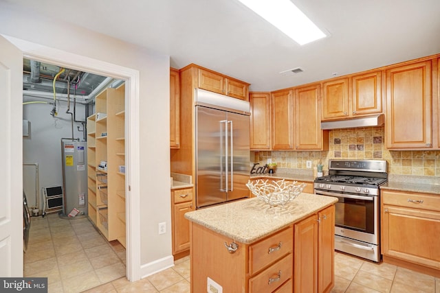 kitchen featuring light stone countertops, decorative backsplash, stainless steel appliances, water heater, and a center island