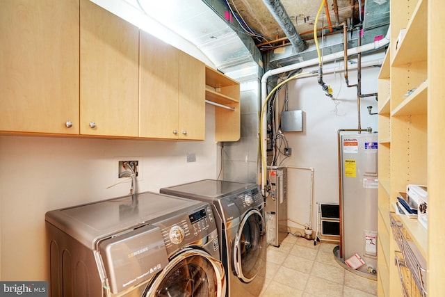 laundry area with cabinets, electric water heater, and separate washer and dryer