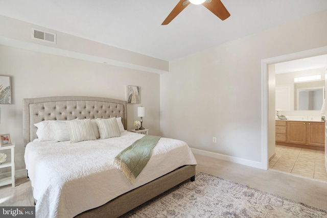 bedroom featuring sink, ceiling fan, light colored carpet, and ensuite bathroom