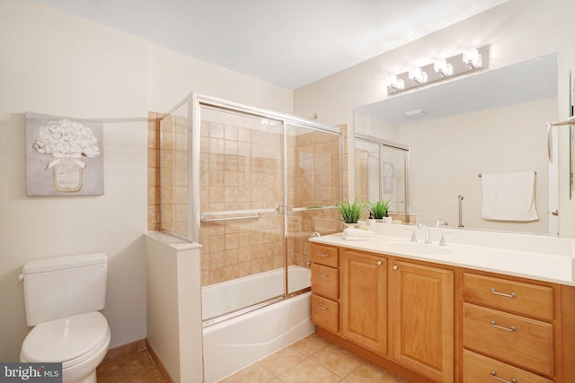 full bathroom featuring tile patterned floors, vanity, toilet, and bath / shower combo with glass door