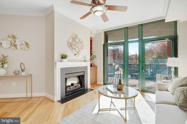 living room with hardwood / wood-style floors, a wall of windows, ceiling fan, and crown molding