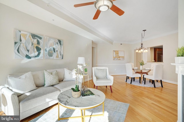 living room featuring crown molding, ceiling fan with notable chandelier, and hardwood / wood-style flooring