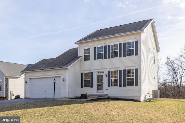 colonial-style house with an attached garage, roof with shingles, aphalt driveway, and a front yard