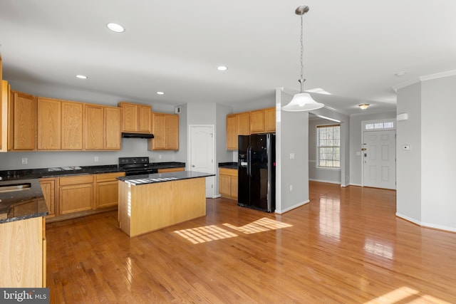 kitchen featuring ornamental molding, black appliances, a center island, light hardwood / wood-style floors, and hanging light fixtures