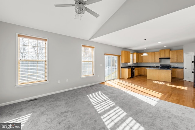 kitchen featuring a healthy amount of sunlight, pendant lighting, and light carpet