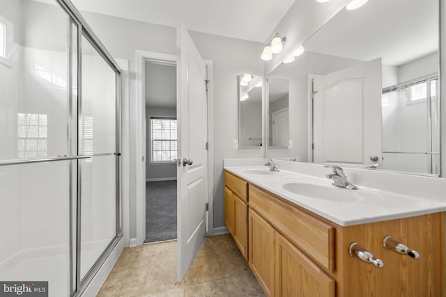 bathroom featuring a shower with door, vanity, and tile patterned flooring