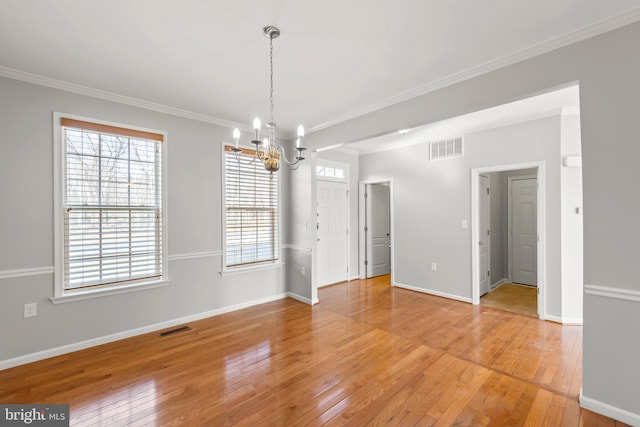 spare room with visible vents, crown molding, light wood-style flooring, and baseboards