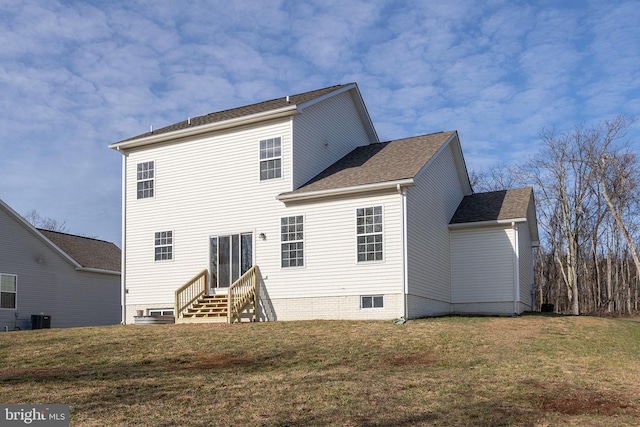 rear view of house with entry steps, central air condition unit, and a lawn