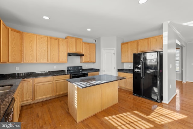 kitchen featuring black appliances, dark stone countertops, light wood-type flooring, light brown cabinetry, and a kitchen island