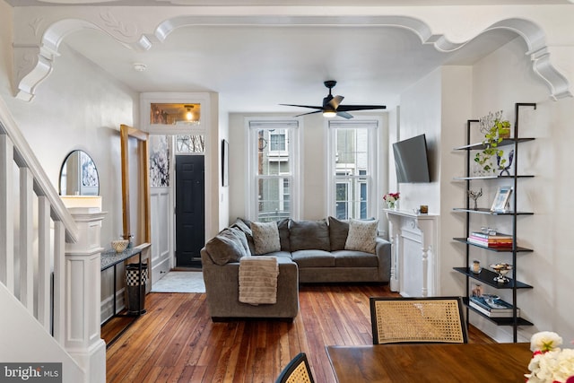 living room with ceiling fan, dark hardwood / wood-style flooring, and decorative columns