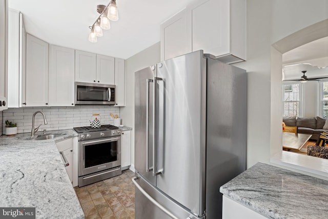 kitchen featuring appliances with stainless steel finishes, sink, decorative backsplash, and white cabinets