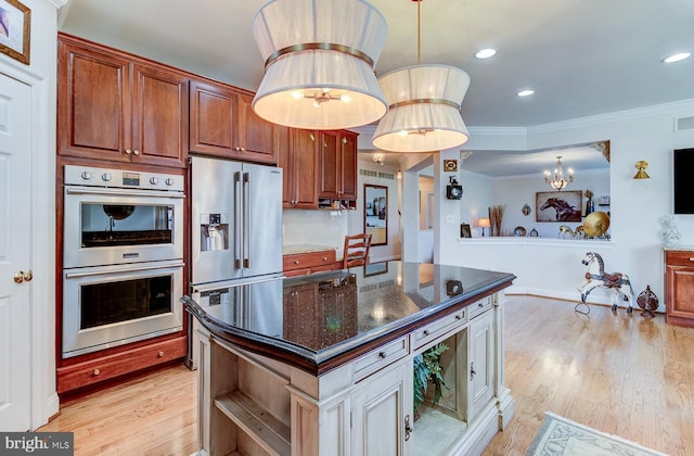 kitchen featuring stainless steel appliances, a chandelier, pendant lighting, decorative backsplash, and a kitchen island