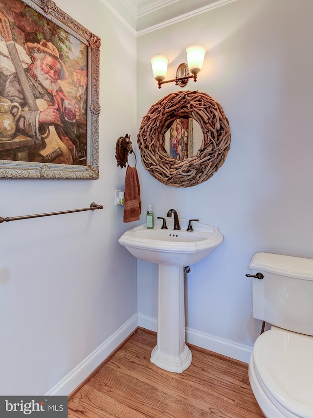 bathroom featuring hardwood / wood-style floors, toilet, and ornamental molding