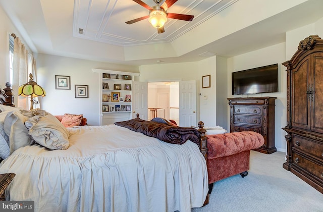 carpeted bedroom featuring a raised ceiling and ceiling fan