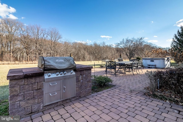 view of patio with a hot tub, grilling area, and exterior kitchen