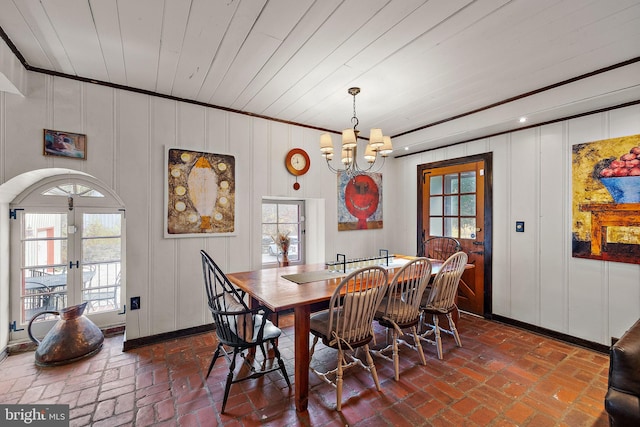 3007 Faulkland Rd, Wilmington, DE 19808 - dining space featuring french doors, a chandelier, a decorative wall, brick flooring, and baseboards