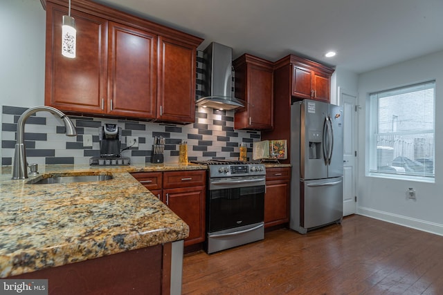 kitchen with appliances with stainless steel finishes, tasteful backsplash, light stone counters, wall chimney exhaust hood, and sink