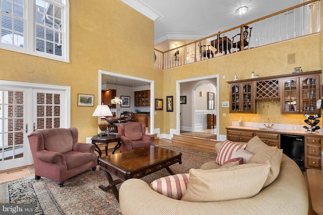 living room with visible vents, arched walkways, ornamental molding, wood finished floors, and indoor wet bar