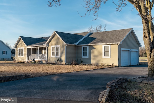 ranch-style home with a porch and a garage