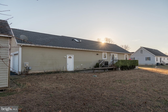 back house at dusk featuring a garage