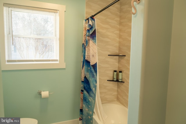 bathroom with shower / tub combo and toilet