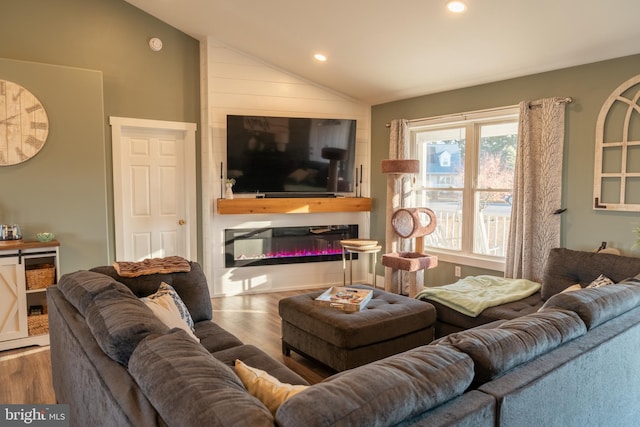 living room featuring a fireplace, hardwood / wood-style floors, and vaulted ceiling