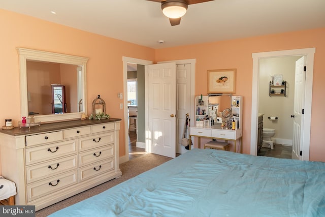 carpeted bedroom featuring ceiling fan and ensuite bath