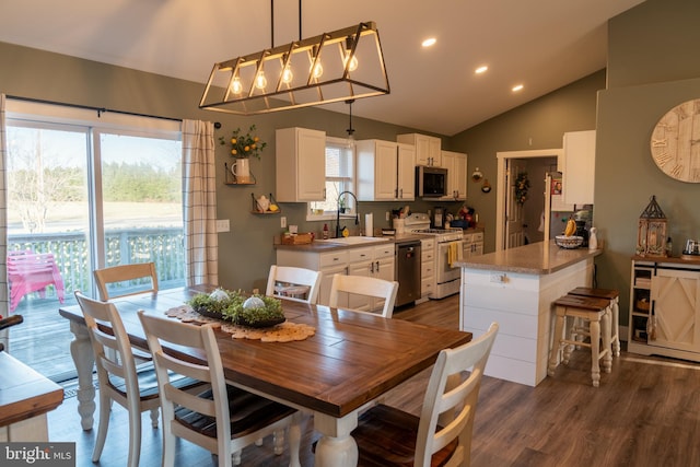 dining room featuring dark hardwood / wood-style flooring, sink, and lofted ceiling