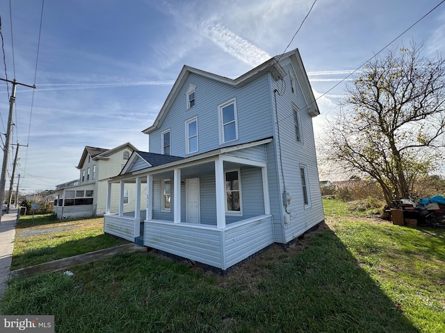 view of side of property featuring a lawn and a porch