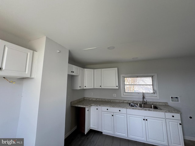 kitchen with dark hardwood / wood-style floors, white cabinetry, and sink