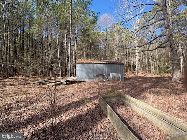 view of yard with an outbuilding and a forest view