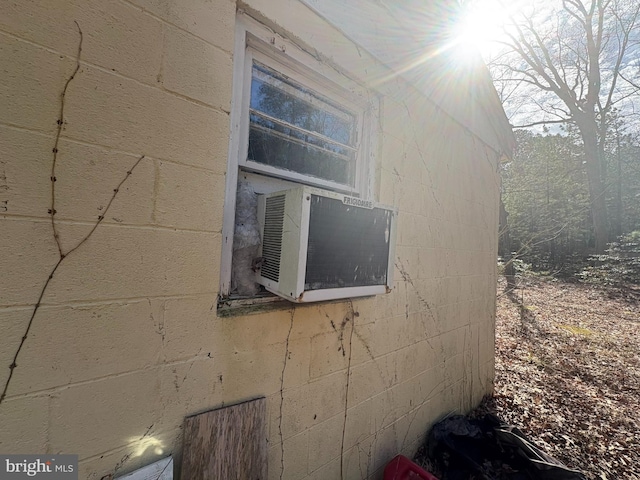 view of side of home with concrete block siding and cooling unit