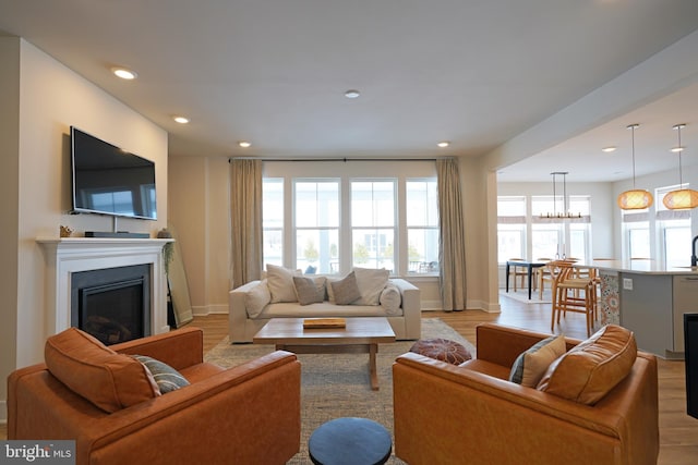 living room featuring an inviting chandelier and light wood-type flooring