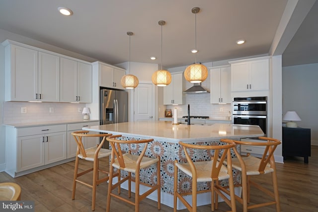 kitchen featuring a breakfast bar, light hardwood / wood-style flooring, white cabinets, and stainless steel appliances