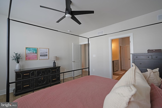 bedroom with hardwood / wood-style floors, ensuite bathroom, and ceiling fan