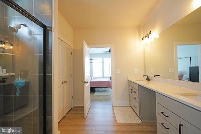 bathroom with ceiling fan, vanity, wood-type flooring, and a shower with shower door