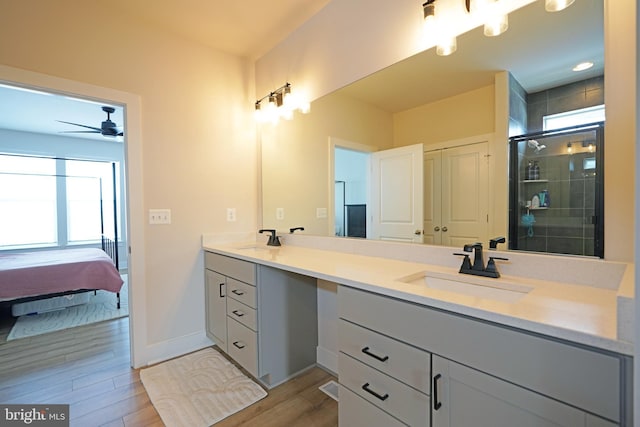 bathroom with ceiling fan, wood-type flooring, walk in shower, and vanity