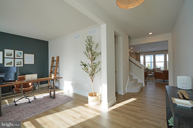 home office with light hardwood / wood-style floors