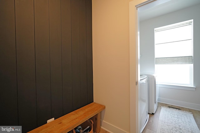 laundry room featuring washing machine and dryer and light hardwood / wood-style flooring