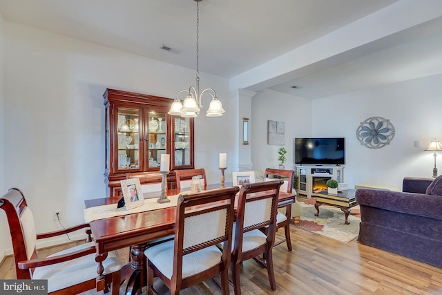 dining space featuring a notable chandelier and light hardwood / wood-style floors