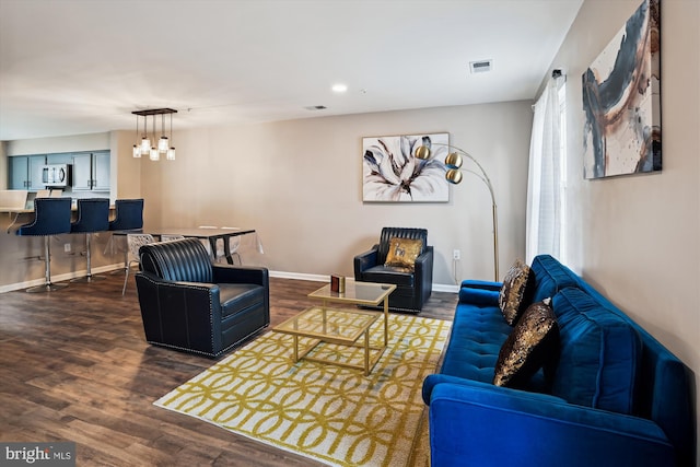 living room featuring a chandelier and dark hardwood / wood-style floors