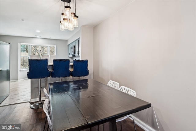 dining space with hardwood / wood-style floors and a chandelier