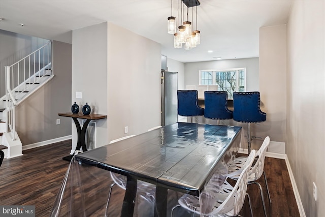 dining area featuring dark wood-type flooring and a chandelier