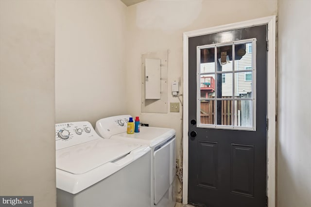 clothes washing area featuring electric panel and separate washer and dryer